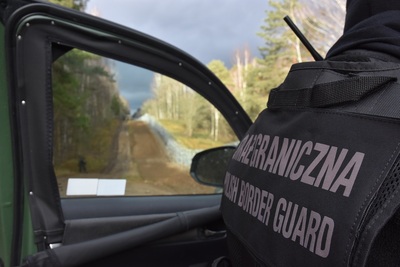 Funkcjonariusz Straży Granicznej na tle granicy RP 