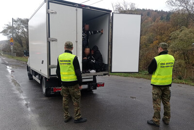 funkcjonariusze SG oraz auto na drodze, w aucie cudzoziemcy 