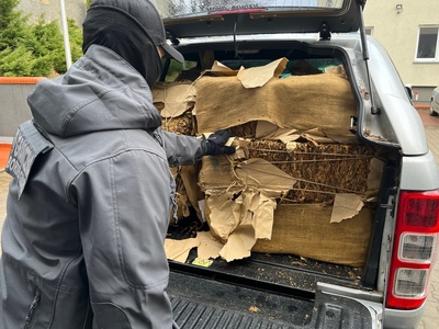 Funkcjonariusz Straży Granicznej z zatrzymanym suszem tytoniowym 