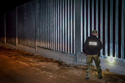 funkcjonariusz SG nocą przy barierze 