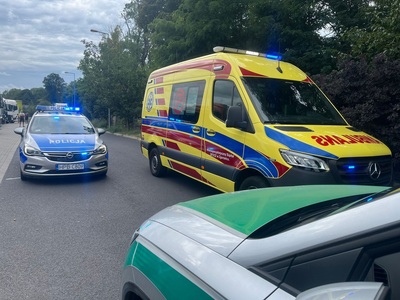 Przód pojazdu służbowego Straży Granicznej, obok ambulans, za nimi pojazd Policji. Przód pojazdu służbowego Straży Granicznej, obok ambulans, za nimi pojazd Policji.