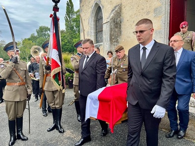 Poczet sztandarowy oddaje honor, obok wynoszona jest z kościoła trumna przykryta flagą Poczet sztandarowy oddaje honor, obok wynoszona jest z kościoła trumna przykryta flagą