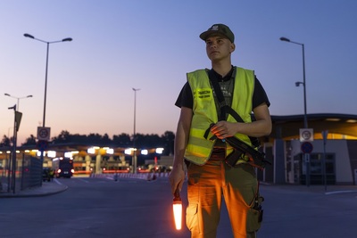 Funkcjonariusz na tle przejścia granicznego 