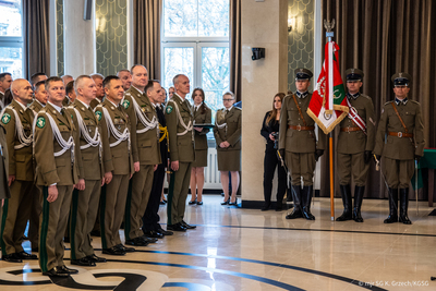 Uroczystość z okazji Narodowego Święta Niepodległości w Komendzie Głównej Straży Granicznej Zdjęcie odznaczonych funkcjonariuszy i pocztu sztandarowego Straży Granicznej.