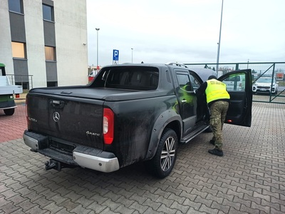 Mercedes poszukiwany w Niemczech został odzyskany przez Straż Graniczną Funkcjonariusz Straży Granicznej kontroluje samochód.