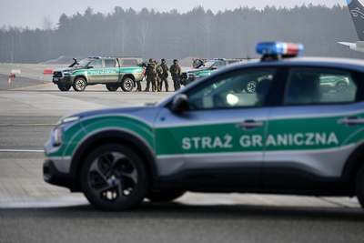 Funkcjonariusze Straży Granicznej podczas ćwiczenia służb CEPEX 2024, stoją pomiędzy pojazdami służbowymi. Funkcjonariusze Straży Granicznej podczas ćwiczenia służb CEPEX 2024, stoją pomiędzy pojazdami służbowymi.