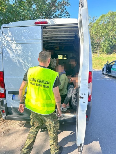 Funkcjonariusz Straży Granicznej podczas wykonywania czynności służbowych przy busie z cudzoziemcami. Funkcjonariusz Straży Granicznej podczas wykonywania czynności służbowych przy busie z cudzoziemcami.