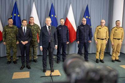 Minister SWiA przemawia, w tle stoją szefowie służb, za nimi flagi Polski i Unii Europejskiej, fot. MSWiA Minister SWiA przemawia, w tle stoją szefowie służb, za nimi flagi Polski i Unii Europejskiej, fot. MSWiA