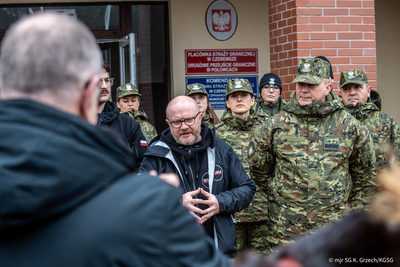 Komendant Główny Straży Granicznej, Wiceminister MSWiA stoją przed Placówką SG w Czeremsze, w tle funkcjonariusze SG przed nimi dziennikarze Komendant Główny Straży Granicznej, Wiceminister MSWiA stoją przed Placówką SG w Czeremsze, w tle funkcjonariusze SG przed nimi dziennikarze