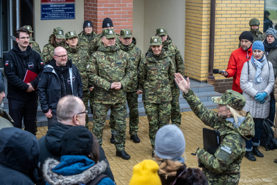 Komendant Główny Straży Granicznej, Wiceminister MSWiA stoją przed Placówką SG, w tle funkcjonariusze SG przed nimi dziennikarze Komendant Główny Straży Granicznej, Wiceminister MSWiA stoją przed Placówką SG, w tle funkcjonariusze SG przed nimi dziennikarze