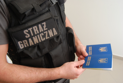 Funkcjonariusz Straży Granicznej trzyma dwa ukraińskie paszporty Funkcjonariusz Straży Granicznej trzyma dwa ukraińskie paszporty