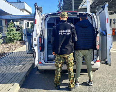 Funkcjonariusz Straży Granicznej z zatrzymanym mężczyzną. Funkcjonariusz Straży Granicznej z zatrzymanym mężczyzną.