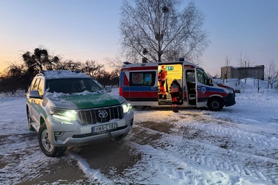 Pojazd służbowy Straży Granicznej w tle ambulans Pojazd służbowy Straży Granicznej w tle ambulans