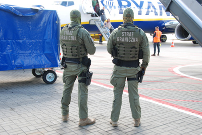 Funkcjonariusze Straży Granicznej podczas wykonywania czynności służbowych na płycie lotniska Funkcjonariusze Straży Granicznej podczas wykonywania czynności służbowych na płycie lotniska