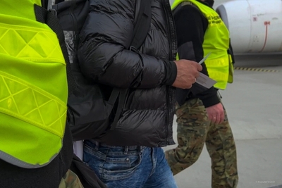 Funkcjonariusze SG prowadzą osobę deportowaną z Polski 